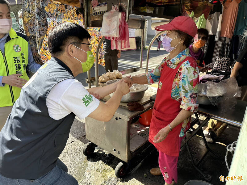 民進黨新北市長候選人林佳龍（左）今天上午至汐止金龍市場掃街拜票，再次提出一區一盛典想法，強調要讓新北29個行政區城鄉均衡發展。（記者魏瑾筠攝）