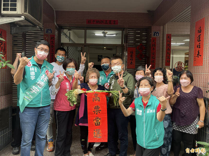 有民眾在自家門口前等候，特地送上菜頭、蒜頭及「高票當選」的賀聯祝福蔡其昌。（記者林旻臻攝）