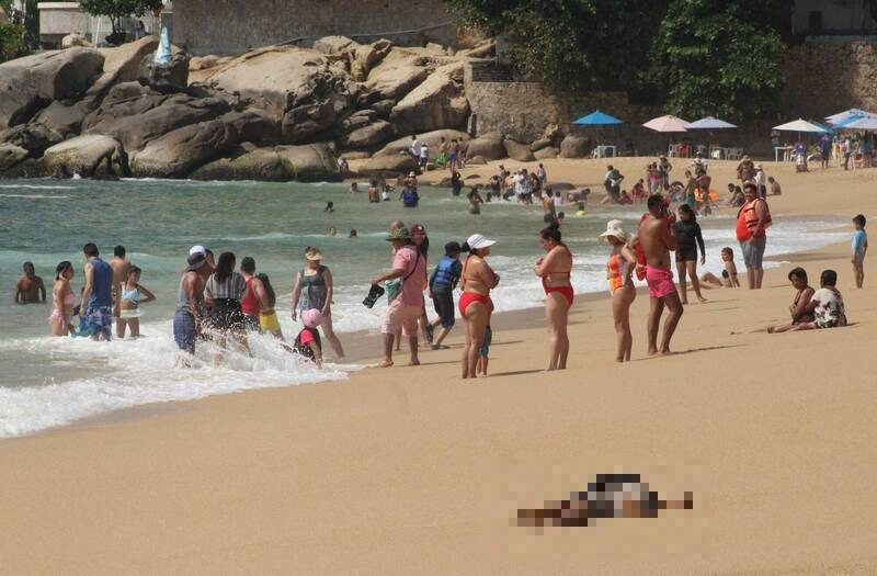 墨西哥海滩出现两具被沖上岸的尸体，一旁游客则是十分淡定。（路透）(photo:LTN)