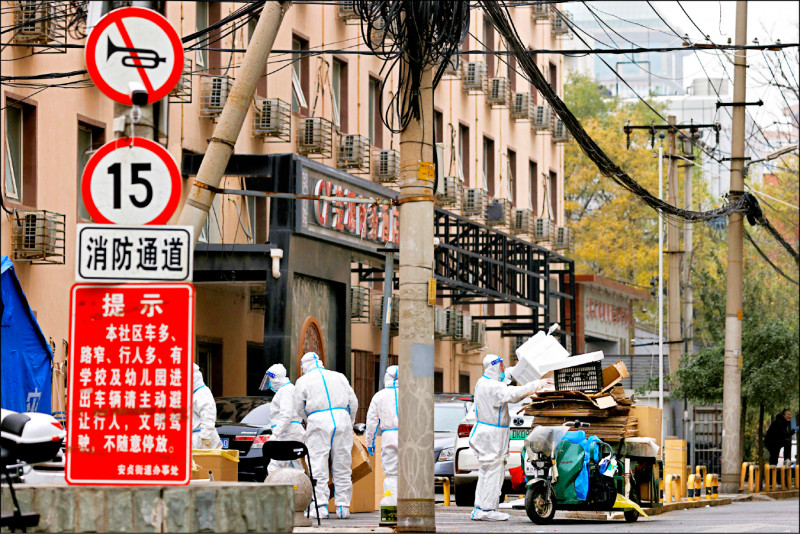 防疫工作人员十八日在北京一处封控社区处理垃圾。（路透）(photo:LTN)