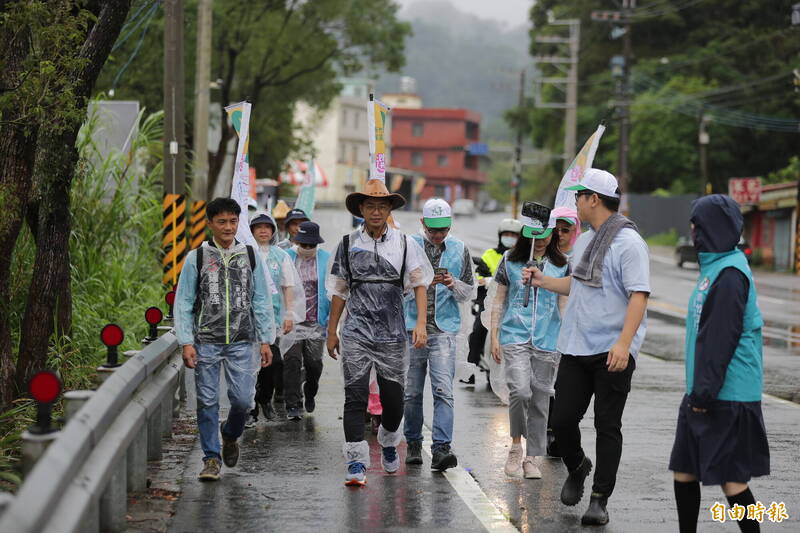 民進黨新竹縣長候選人周江杰的「逆風行腳」今天邁入第3天，即便碰到下雨，一行人也持續冒雨向前行。（記者黃美珠攝）