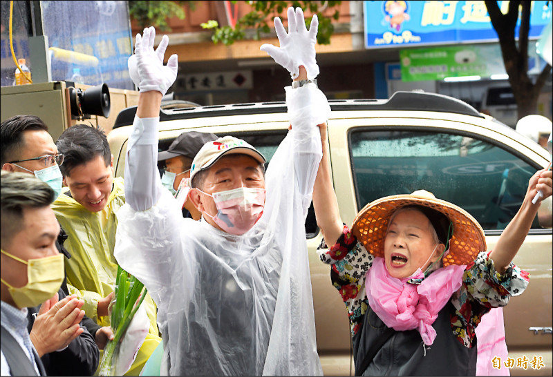 民進黨台北市長候選人陳時中把握時間最後衝刺，在大雨中掃街拜票。（記者劉信德攝）