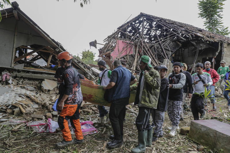 11月25日在席安約鎮，搜救人員與村民正在搬運罹難者的遺體。印尼國家災害應變總署指出，本次強震迄今已累計有310人死亡。（歐新社）