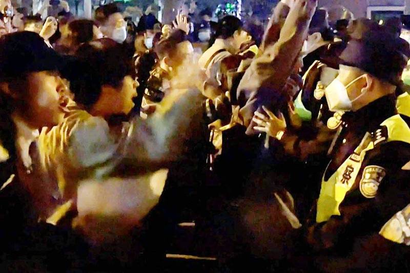 Demonstrators in Shanghai yesterday shout slogans as police hold their positions in a screengrab taken from eyewitness video footage.
Photo: AFP