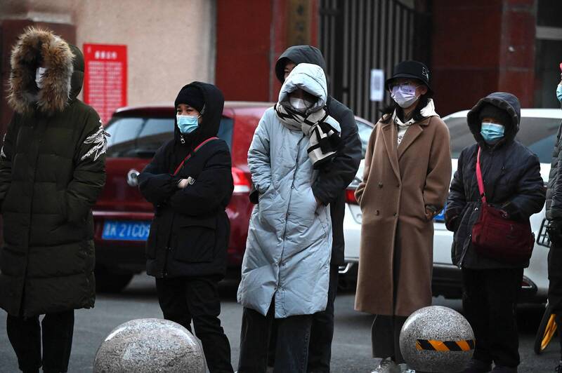 北京许多核酸检测点一夜之间关闭，但要进入各处地点却仍然需要核酸证明，导致市民只能顶着10度以下的低温，在寒风中排队做核酸。（法新社）(photo:LTN)