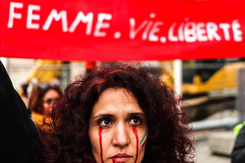 伊朗库德族女子艾米尼9月间疑因未戴好头巾，遭道德警察羁押后死亡，引发大规模反政府抗议运动，当局4日宣布废除道德警察。图为法国声援艾米尼的抗议活动。（法新社）(photo:LTN)