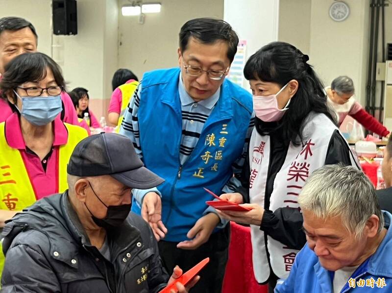 林榮三基金會代表人瓏山林台北中和飯店總經理朱少菡（右）致贈街友紅包關懷，中為三重區長陳奇正。（記者翁聿煌攝）