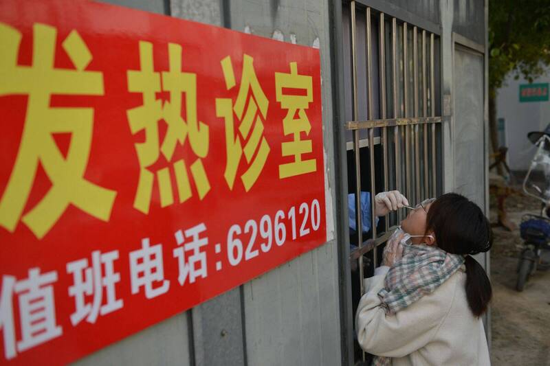 中国安徽省一处发烧门诊医护人员15日为一名女子检测武肺病毒。（法新社）(photo:LTN)