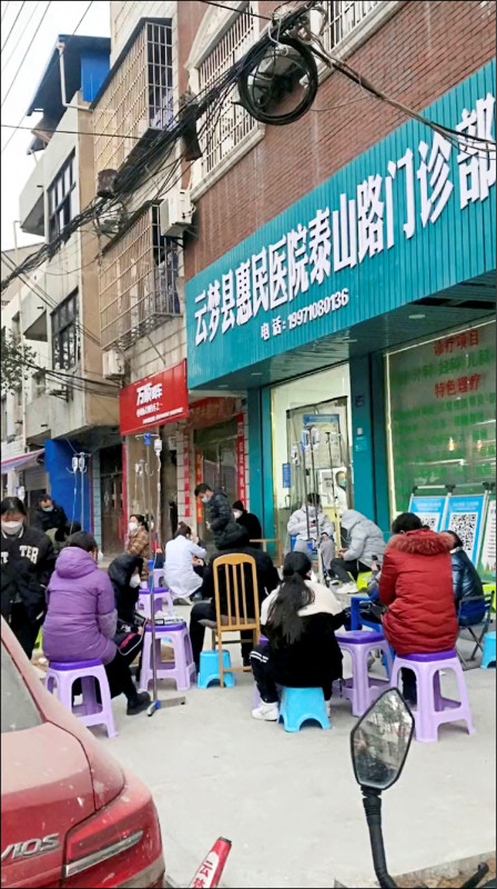 网传影片显示，湖北省孝感市一群民众十四日穿着厚重外套，坐在一家诊所外吊点滴。（路透）(photo:LTN)