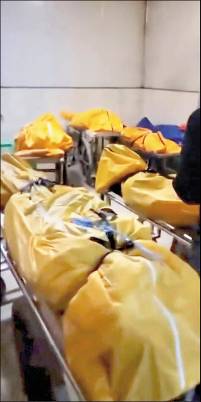 中国社群媒体22日流传的照片，显示重庆确诊死亡者被放入尸袋后，多具尸体在一栋大楼的装货区排开。（路透）(photo:LTN)