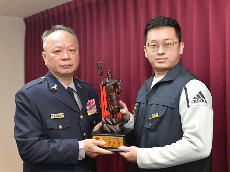 即將退休的台中警局長蔡蒼柏（左），送破案警察陳柏儒（右）「關公神像」等大禮。（中市警局提供）