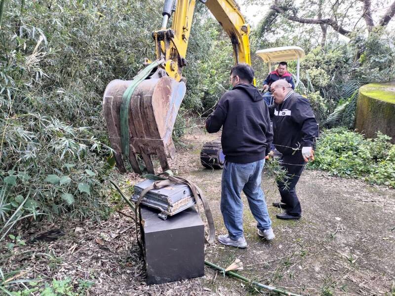 犯嫌將保險箱棄置於桃園山區的斜坡處；因人力難以移動，警方僱用小型挖土機到場，才將保險箱搬到地面。 （記者廖雪茹翻攝）