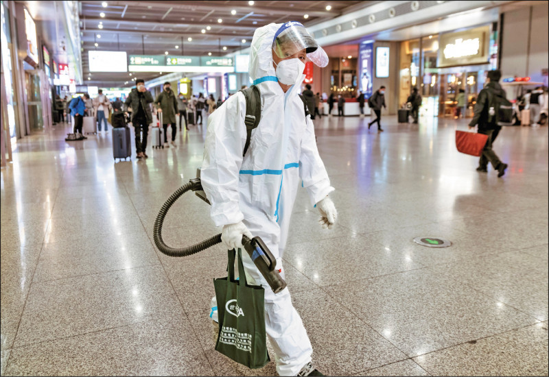 中国疾控中心流行病学前首席科学家曾光分析，目前尚未迎来重症高峰，估计发病高峰还会持续二至三个月。图为上海地铁站一位旅客身着防护衣。（欧新社）(photo:LTN)