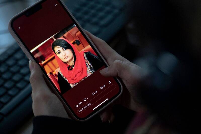 阿富汗警方今天表示，多名枪手暗夜闯入一名前国会女议员纳比萨达位于喀布尔的家中，枪杀她和她的一名保镖。图为一名妇女正从手机上观看纳比萨达的照片。（法新社）(photo:LTN)