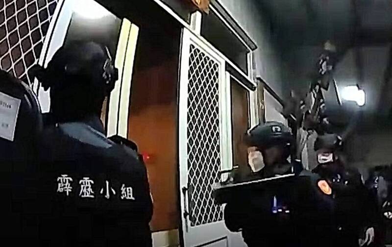 彰化縣和美警分局在伸港一處工廠鐵皮屋查獲職業賭場，霹靂小組破門而入。（彰化縣警方提供）