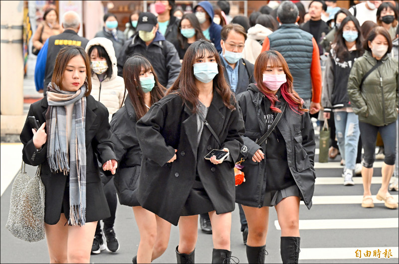 中央氣象局預估十天連假有兩波冷空氣襲台，北東易雨、中南部多雲到晴。圖為台北民眾穿著厚重冬衣逛街。（資料照，記者廖振輝攝）