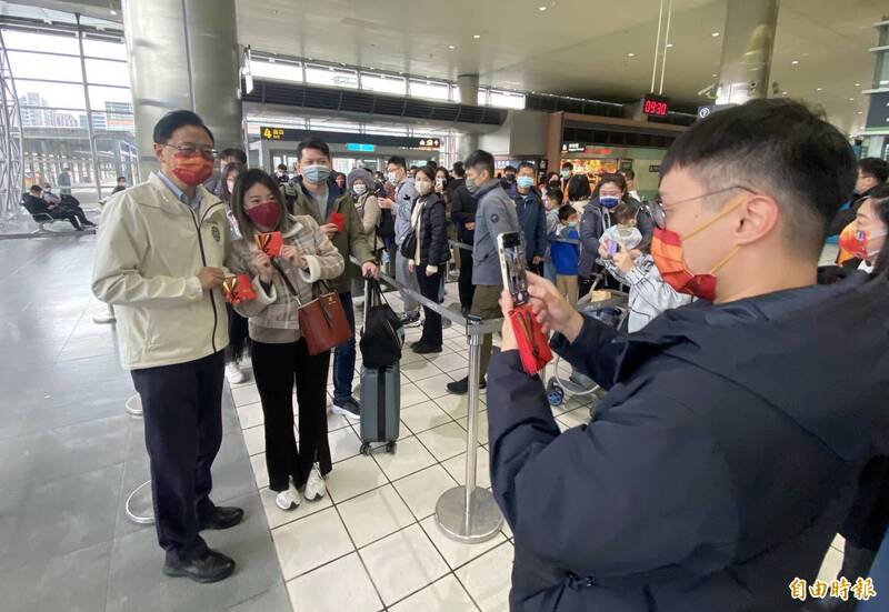 桃園市長張善政（左一）今天上午視察高鐵桃園站旅運狀況，發送小福袋給工作人員、旅客（如圖）並拜年。（記者陳璟民攝）