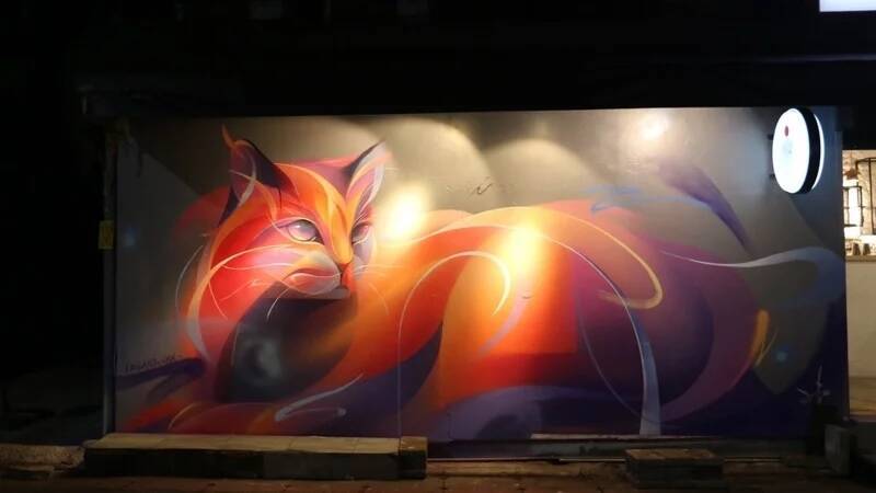 藝術家Leho透過台北通結合AR技術，於「富士堂」進行現場彩繪，以幻獸風格繪製出東區溫暖夜貓。（台北市觀光傳播局提供）