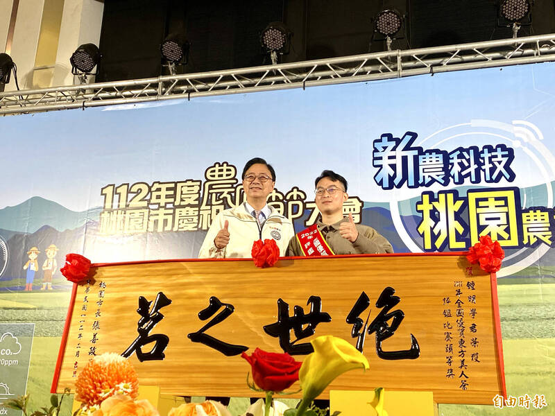 桃園市長張善政（左）昨出席「112年度桃園市慶祝農民節大會」，一一頒發183個獎項表揚優秀農友及團體，其中最年輕的得主為年僅23歲的鍾明學（右），他在接手龍潭區文新製茶廠首年，就一口氣包辦全國優質東方美人茶評鑑比賽2個頭等獎。（記者魏瑾筠攝）