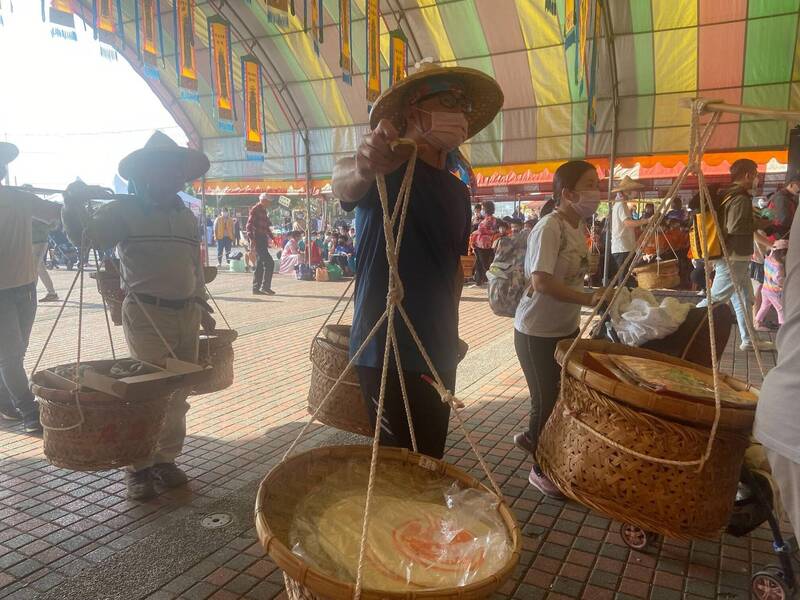 參加擔餅節的家庭，上午先擔著水果餅到西勢廣興宮團拜。（記者劉婉君攝）