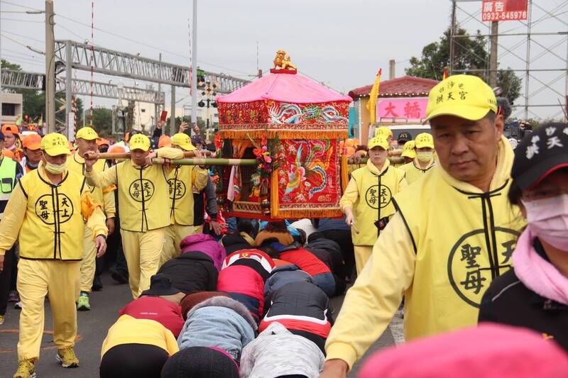 白沙屯媽祖進香首次進入二水鄉老街，民眾跪地準備鑽轎腳祈福。（圖由陳品嘉提供）