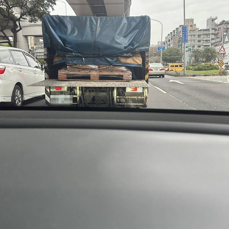 台北一名駕駛剛下麥帥二橋，前車是一輛貨車，他駛近才發現貨車的升降尾門直接平放，沒有警戒標誌。（翻攝爆怨公社）