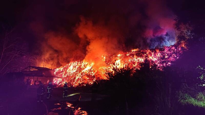 苗栗縣三義鄉西湖村山區一間鐵皮屋發生火警，由於鐵皮屋旁堆放大量木柴，火勢一發不可收拾，經消防人員漏夜灌救14個小時，目前仍持續悶燒。（消防提供）