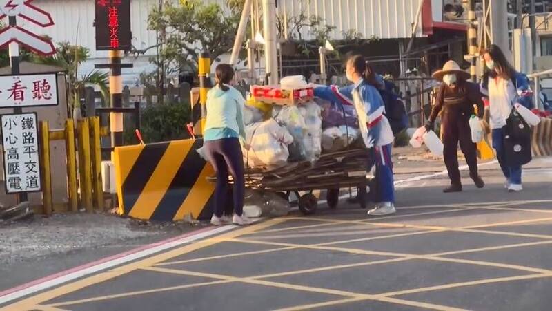 學生幫阿嬤將手推車推離平交道，也牽著阿嬤離開鐵軌，助人的一幕讓人動容。（民眾提供）