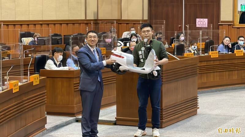 民進黨議員張顥瀚帶來兒童版電動機車送給市長謝國樑，諷刺政見縮水。（記者盧賢秀攝）