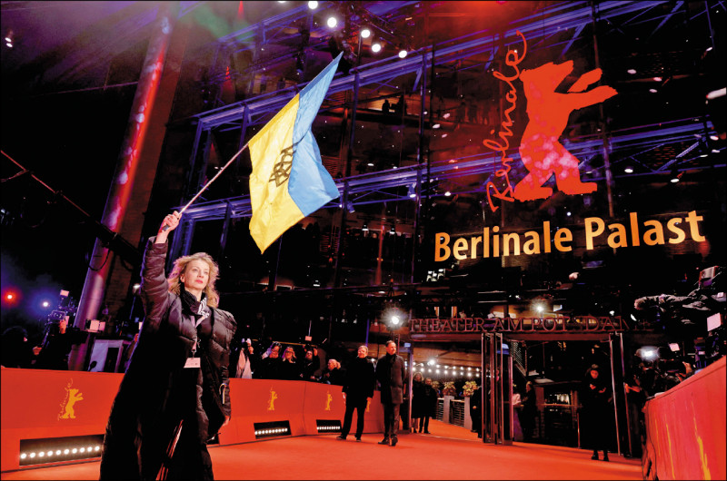第73屆柏林影展25日舉行頒獎典禮，德國女星戴安娜柏格（Diana Berg）在走紅地毯時，高舉烏克蘭國旗譴責俄羅斯侵略。
（路透）