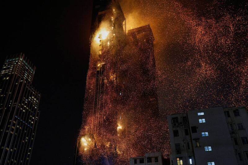 香港尖沙咀高楼发生大火，现场火星四处飘散，危及邻近建筑。（路透）(photo:LTN)