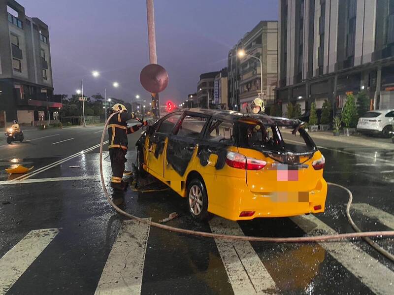 鳳山區家和八街路口，計程車不明原因自撞道路中央的號誌桿，隨後起火，消防人員街到場將火勢撲滅。（讀者提供）