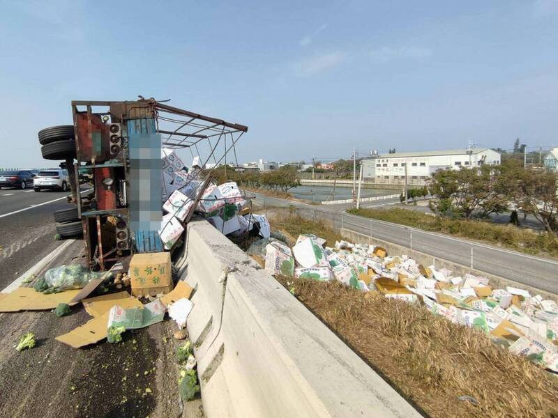 國道1號彰化段兩貨車碰撞翻覆，其中1輛大貨車上的高麗菜、馬鈴薯與青花菜灑落國道。（消防局提供）