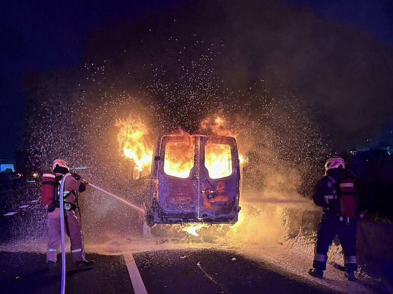 1輛9人座廂型車今天凌晨在國1彰化段火燒車，大火照亮夜空相當猛烈，消防員部署水線搶救。 （消防局提供）