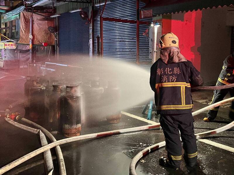 彰化市長壽街一家豆腐店今晚發生火災，消防員冒險搬出33支瓦斯桶，立即灑水降溫防止爆炸。（消防局提供）