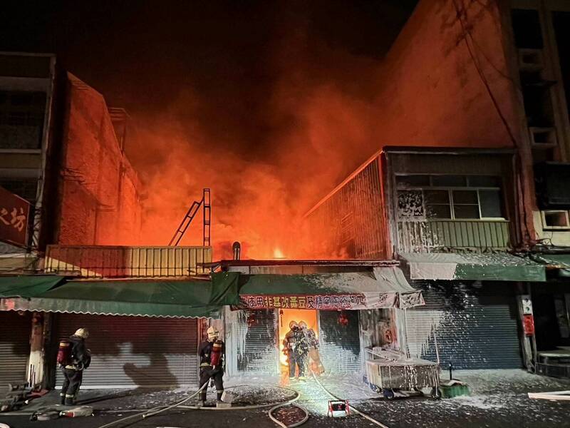 彰化市長壽街一家豆腐店今晚發生火災，大火照亮夜空，消防員部署水線搶救。（消防局提供）
