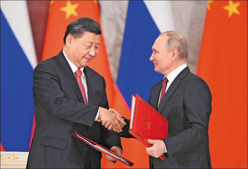 俄罗斯总统普廷与来访的中国国家主席习近平，21日在会谈后签署联合声明的仪式上握手。（法新社）(photo:LTN)