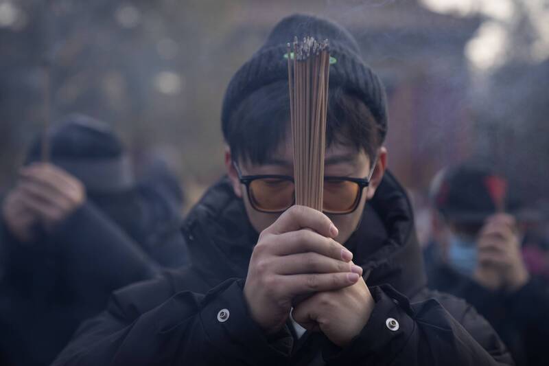 中國年輕人最近興起到寺廟上香的風潮。圖為中國人到北京最大的藏傳佛教寺院雍和宮上香。（美聯社）