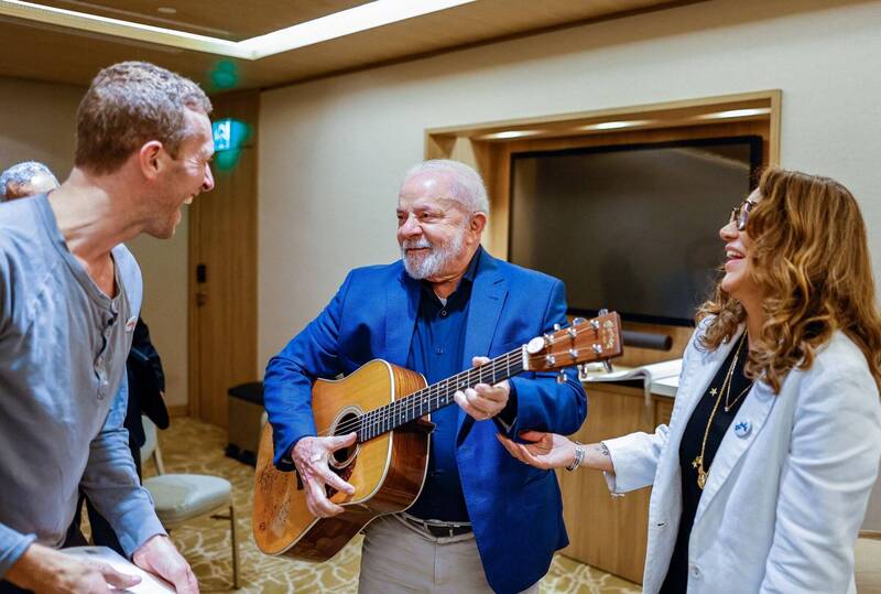 巴西总统鲁拉（中）传出感染A型流感併发肺炎，临时延后赴中国的国是访问行程；图为鲁拉夫妇23日会见酷玩乐团（Coldplay）主唱克里斯马汀（左，Chris Martin），一时兴起拿起吉他同乐。（路透）(photo:LTN)