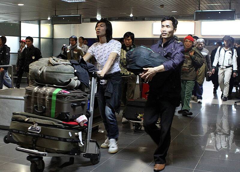 越南移民工人乘坐包机抵达河内内排机场的画面。（法新社）(photo:LTN)