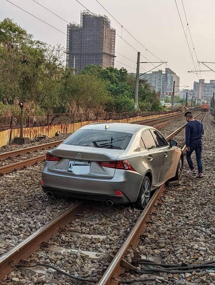 小轎車亂入鐵軌道動彈不得。（記者劉慶侯翻攝）