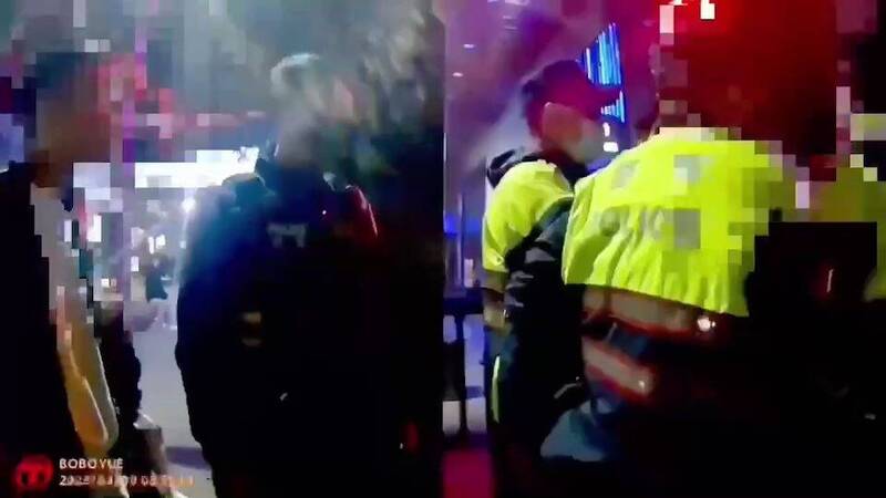 警方在夜店門口將鬧事酒客噴辣椒水帶回警局管束。（記者姚岳宏翻攝）