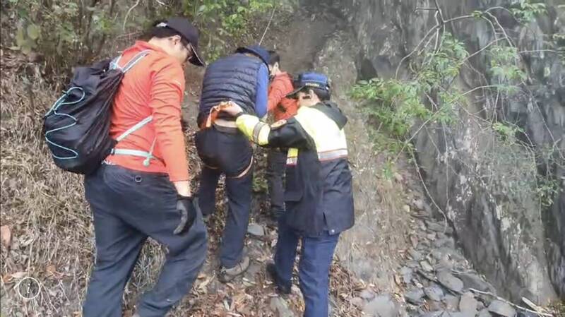 台中市消防及員警將受困峭壁的吳姓夫妻護送下山。（民眾提供）