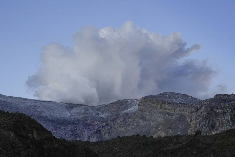 哥倫比亞魯伊斯火山可能噴發，總統要求當地居民馬上撤離，不少人卻因生計不願離開。圖為魯伊斯火山噴出濃煙。（美聯）