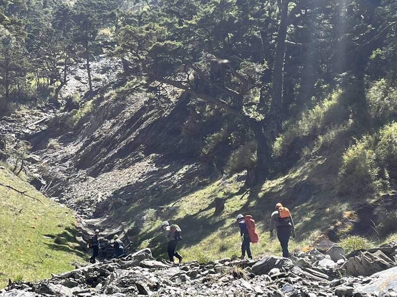 王姓女山友今天上午不慎摔落30米深斷崖邊坡，高市消防局救護人員翻山越嶺趕往救援。（高市消防局提供）