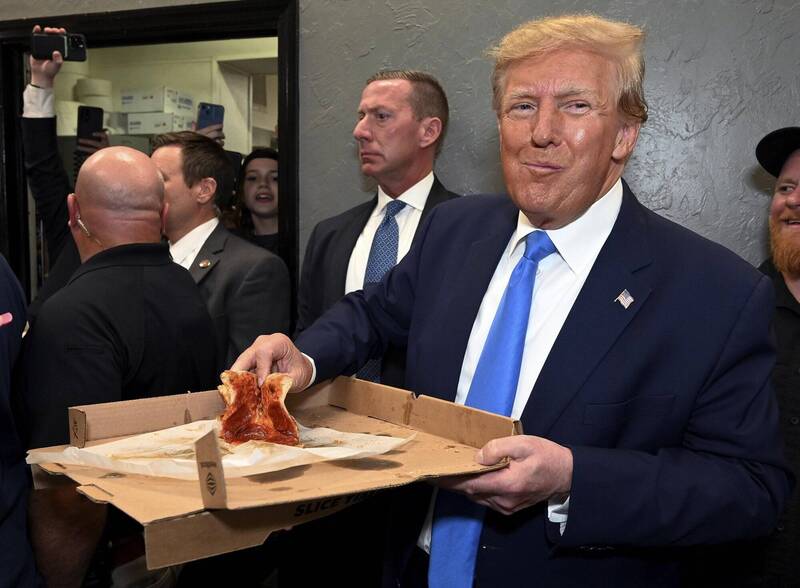 美国前总统川普在2024大选共和党党内民调遥遥领先，吃起披萨相当开心。（美联社）(photo:LTN)