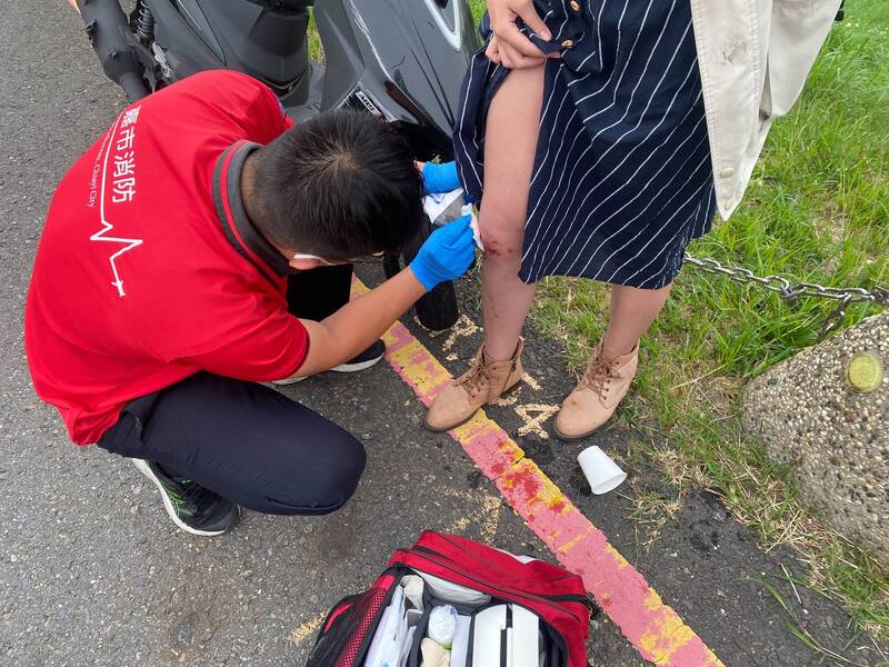 年約24歲女機車騎士在環潭公路不慎自撞，救護人員包紮傷口。（民眾提供）