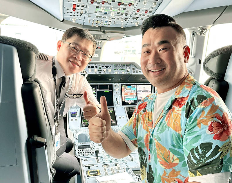 Chinese-Australian vlogger Sam Chui, right, poses for a photograph in the cockpit of a Starlux Airlines plane with captain and company chairman Chang Kuo-wei.
Photo: CNA