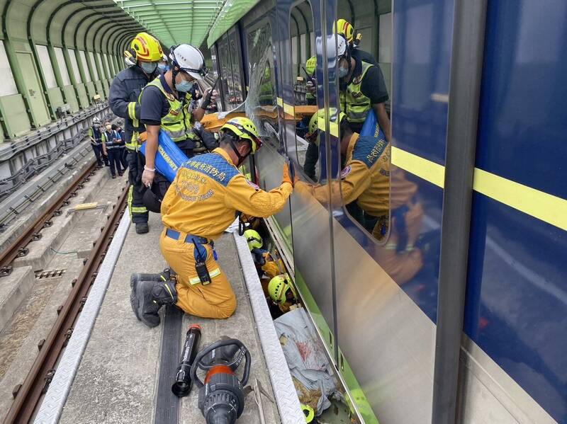 列車撞上吊臂後46分鐘，林淑雅才被發現卡在車廂下軌道，隨後搜人員下軌救出移至月台。（市府提供）