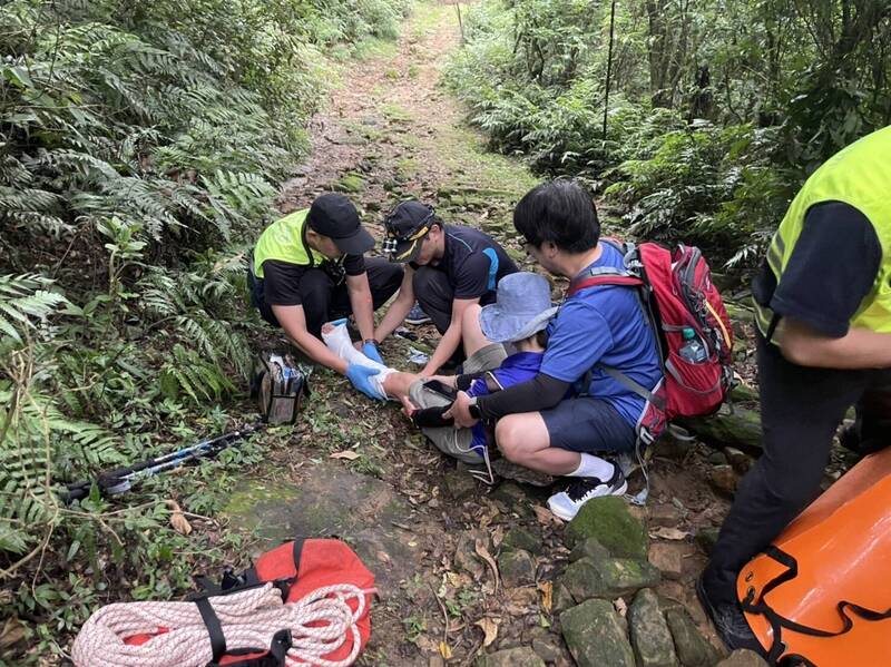 救護人員固定王女骨折處，利用軟式擔架將人搬運下山。（記者吳昇儒翻攝）